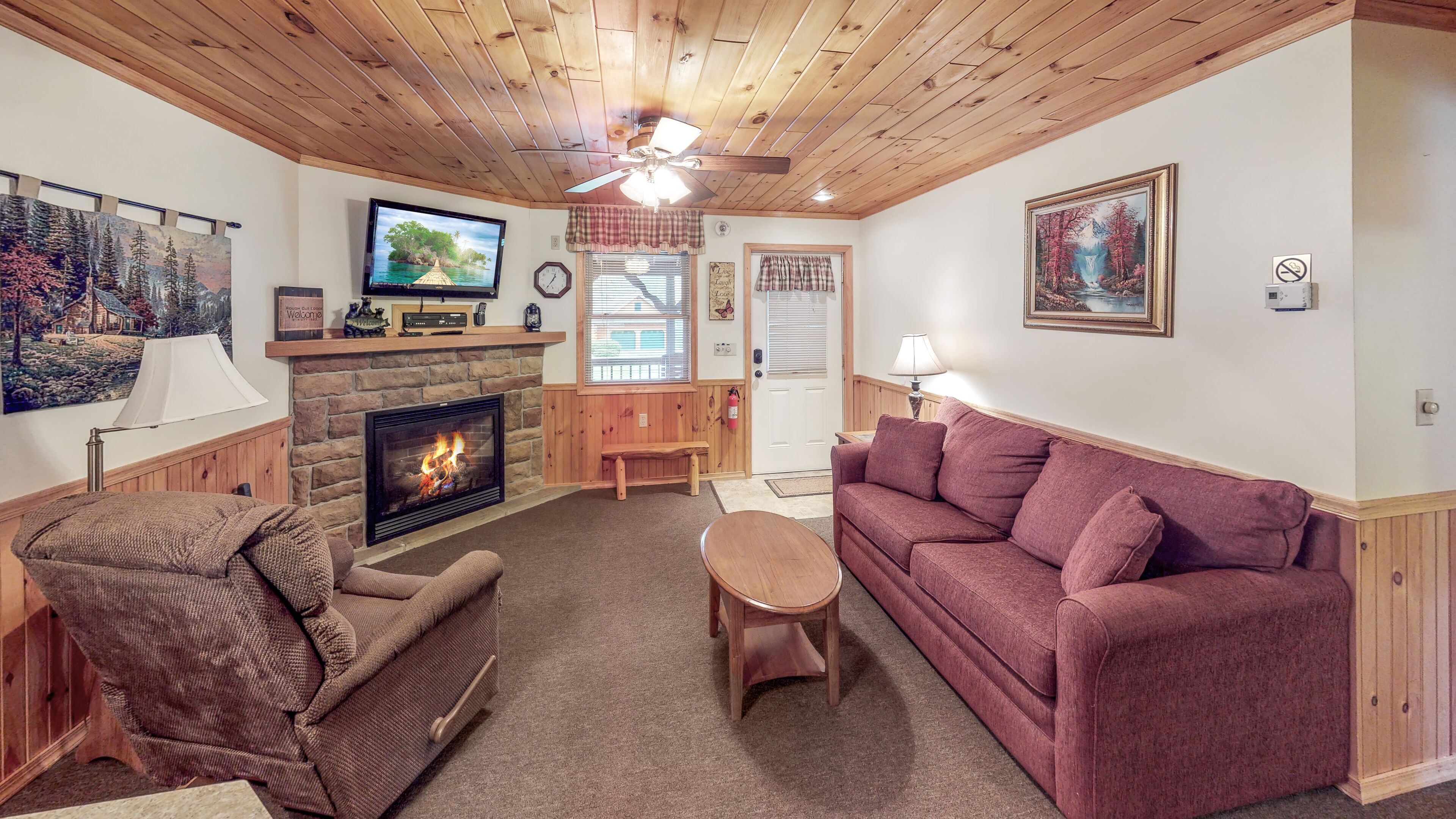 A cozy living room with a fireplace, a television, a sofa, and a coffee table.