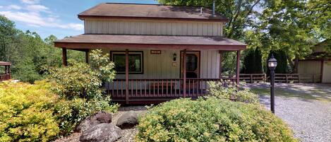 A two-story building with a porch, a sign reading "BEECH," and a gravel pathway leading to it.