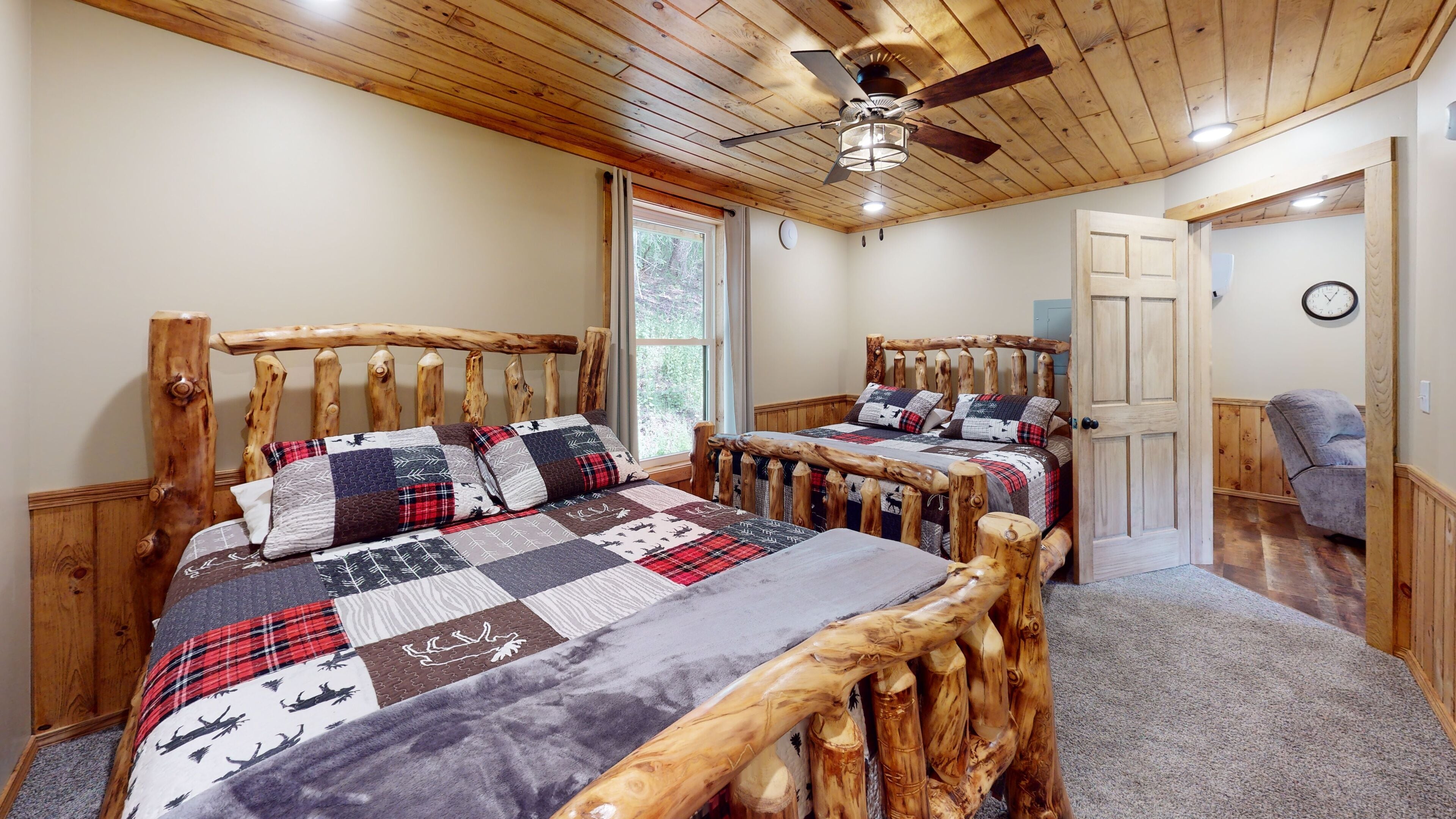 A bedroom with two wooden beds, a ceiling fan, and a window.