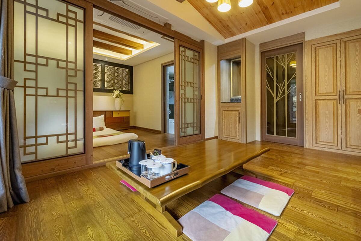 A traditional Japanese-style room with tatami flooring, a low table with a tray of items, and sliding doors with geometric patterns.