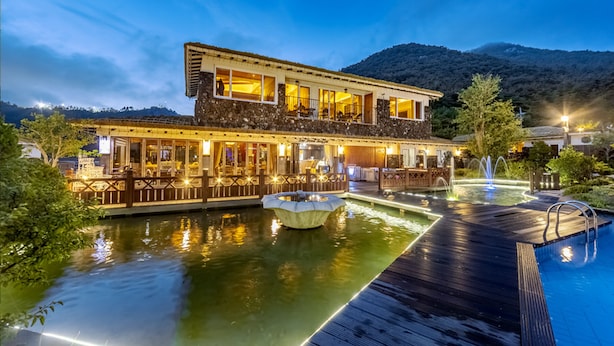A waterfront hotel with a pool, a fountain, and a dining area with outdoor seating. - Hansan Marina Hotel & Resort (Tongyeong)