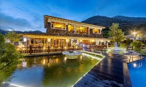 A waterfront hotel with a pool, a fountain, and a dining area with outdoor seating. - Hansan Marina Hotel & Resort (Tongyeong)
