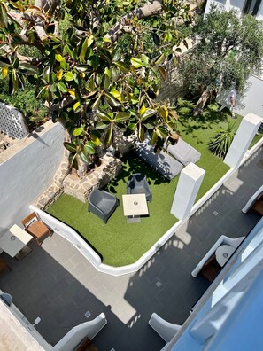 A rooftop garden with a seating area, a small table, and a potted plant. - Matogianni Hotel (Mykonos)