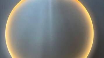 Un objet sphérique doté d’un contour lumineux, qui pourrait être un luminaire ou un élément décoratif.