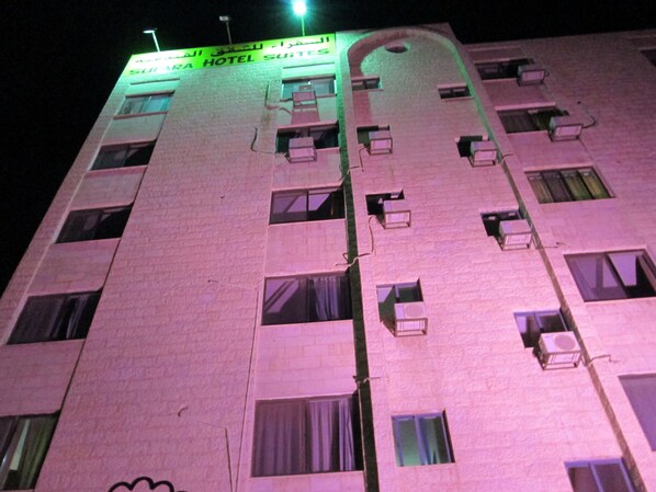 A hotel building with multiple windows and air conditioning units.