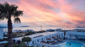 A resort with a pool, white buildings, and a sunset view. - Sofia Village (Mykonos)