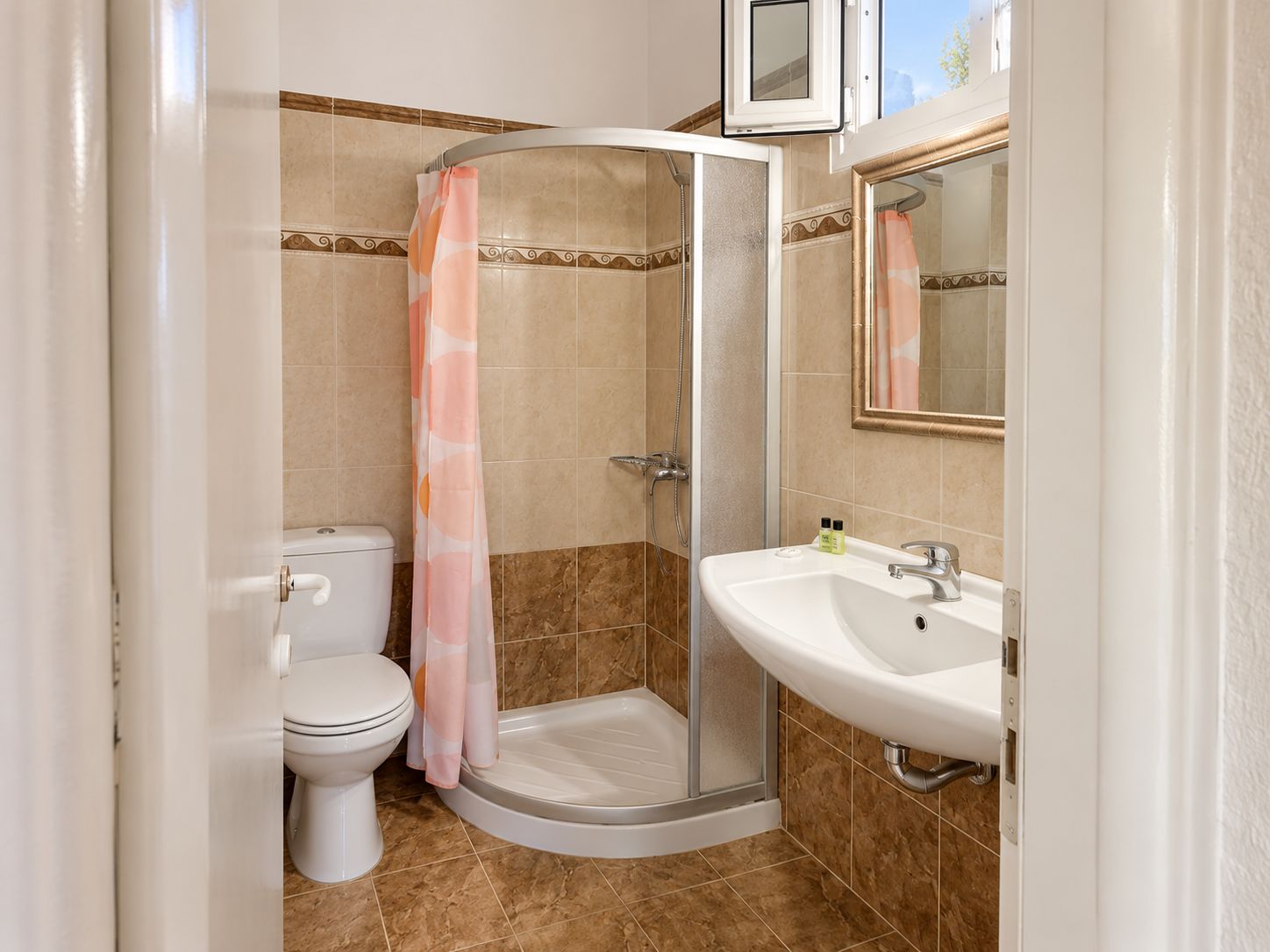 Un baño con ducha, inodoro y lavamanos.