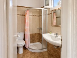 Un baño con ducha, inodoro y lavamanos.