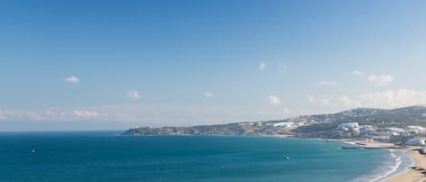 Blick auf die Küste mit Strand, Meer und Gebäuden.