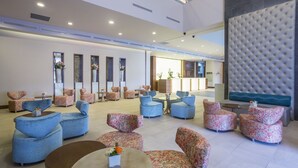 A spacious lobby with multiple seating areas, including sofas and armchairs, arranged around a central coffee table. - Hilton Garden Inn Tanger City Center (Tangier)