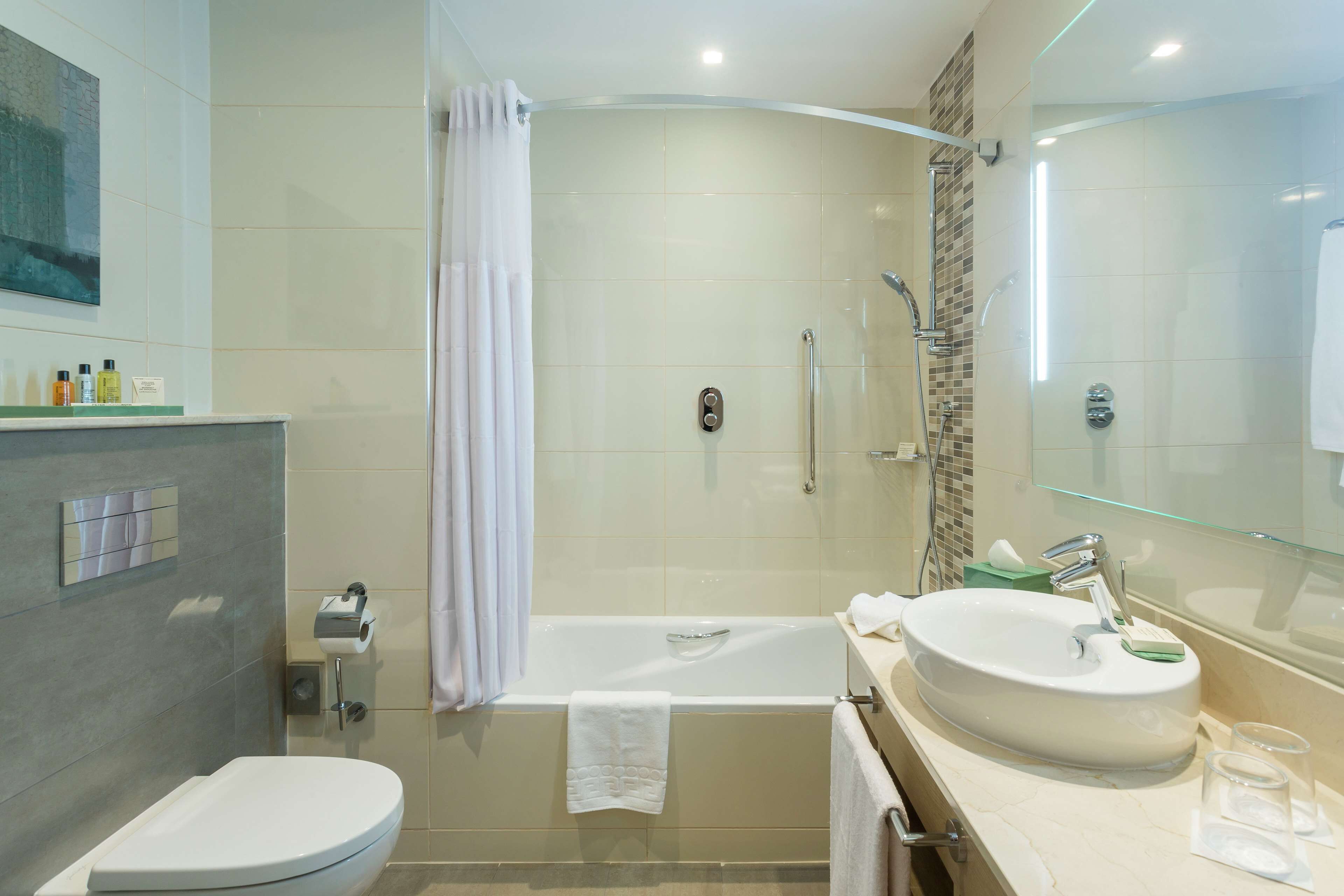 A modern bathroom with a bathtub, toilet, and sink.