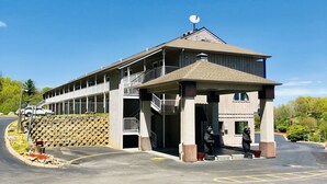 A two-story building with a balcony, a satellite dish, and a stone wall. - Econo Lodge Waynesville (Waynesville)