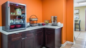 A kitchen with a refrigerator, cabinets, and a countertop with various items. - Econo Lodge Waynesville (Waynesville)