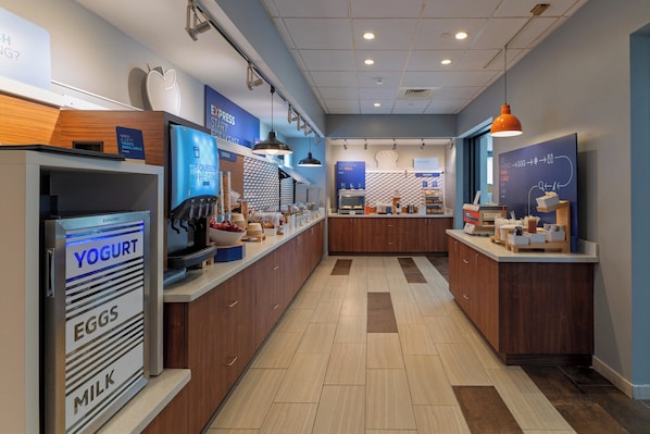 A modern kitchen area with a central island, a refrigerator with labeled compartments, and a counter displaying various food items. - Holiday Inn Express Jasper by IHG (Jasper)