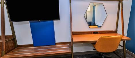 A modern workspace with a desk, chair, and a mounted TV.