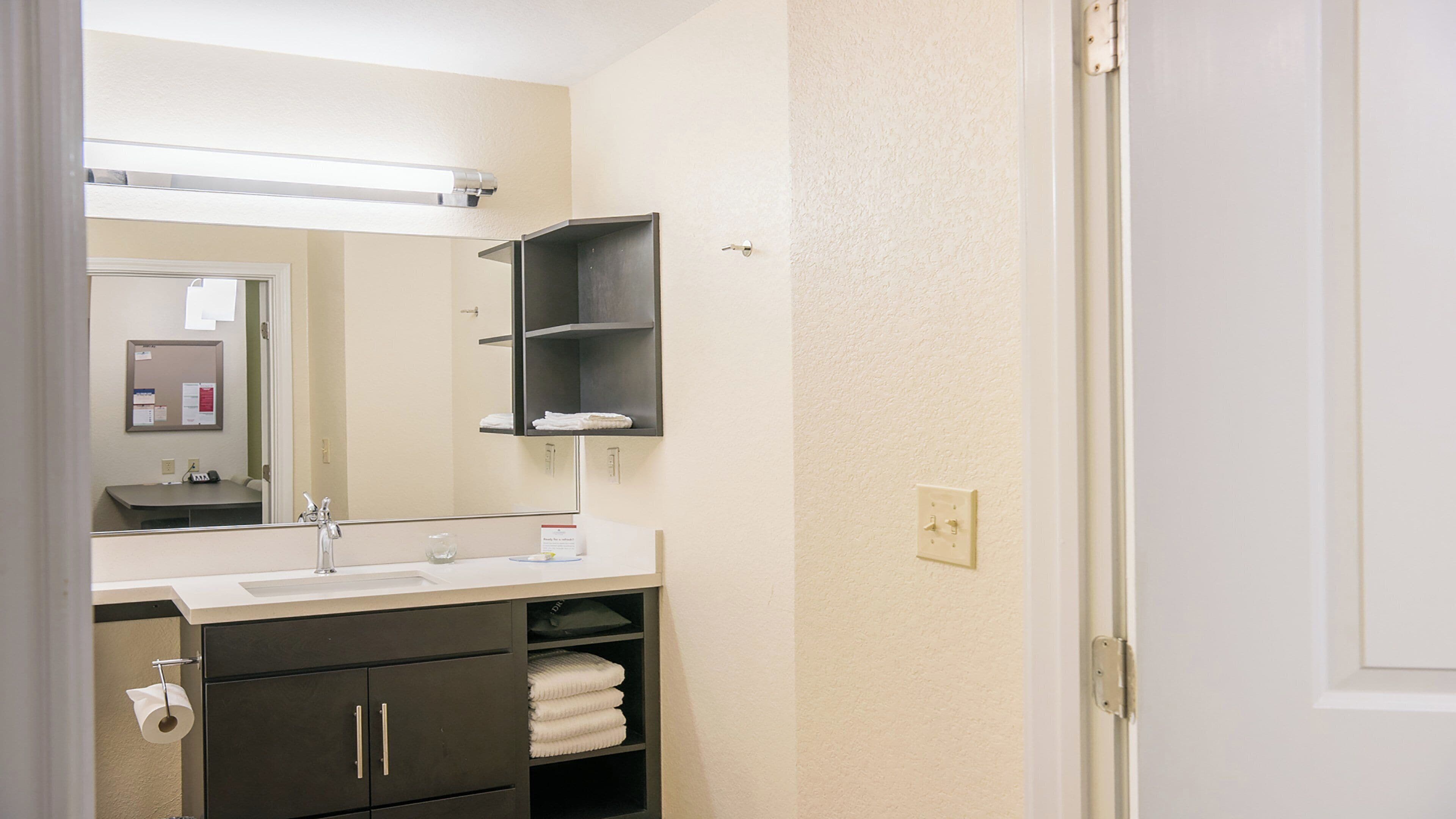 A bathroom with a sink, mirror, towel rack, and a cabinet.