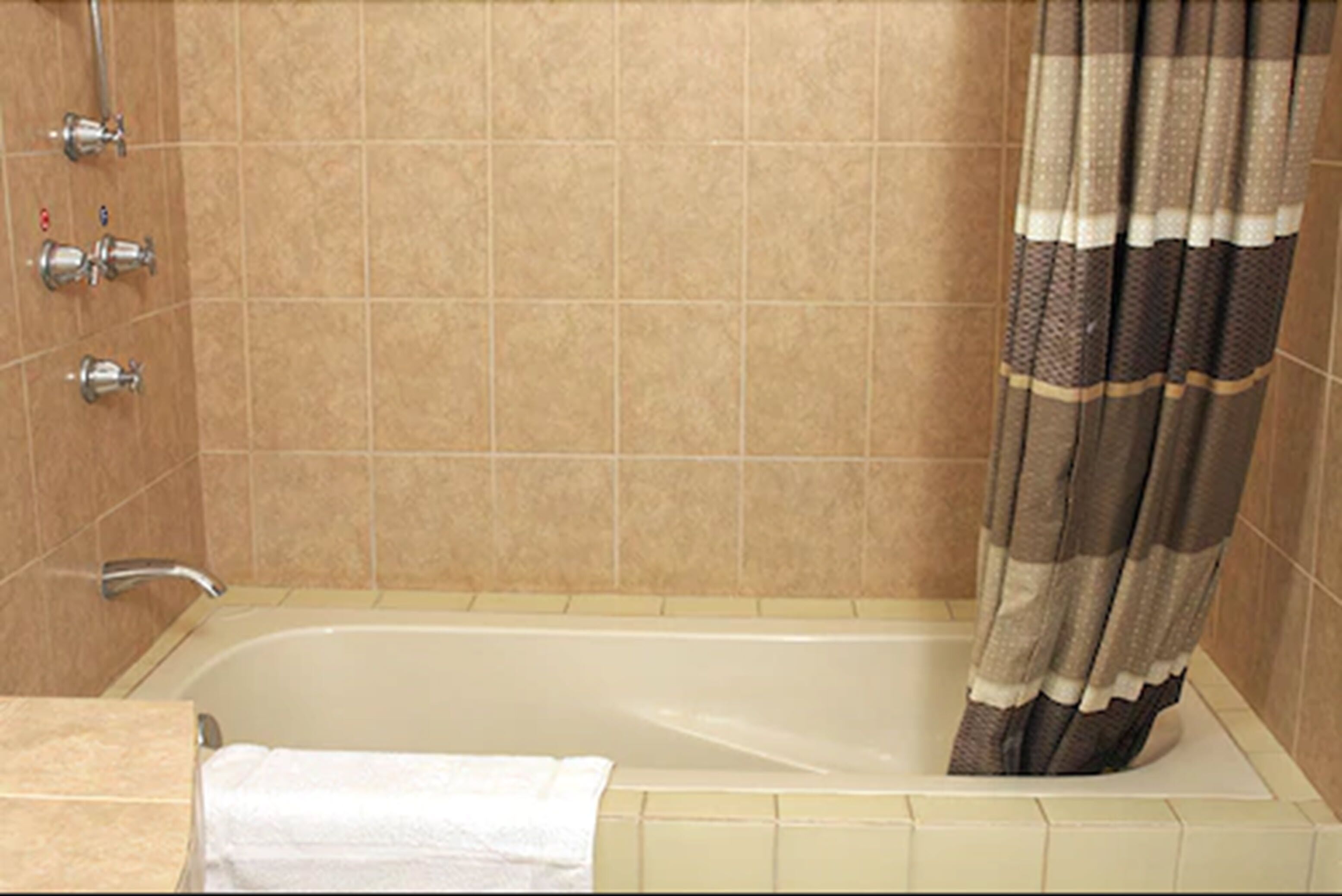 Une salle de bain avec une baignoire, une douche et un porte-serviettes.