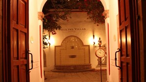 An entrance to Villa del Villar Hotel with a tiled floor, a central fountain, and a clock. - Hotel Villa del Villar (Querétaro)