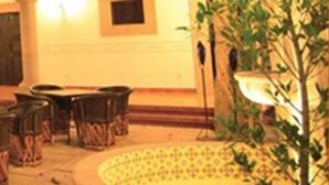 A hotel lobby with a central seating area, a reception desk, and a large window. - Hotel Villa del Villar (Querétaro)