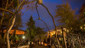 An outdoor garden area with a metal sculpture, stone steps, and trees.