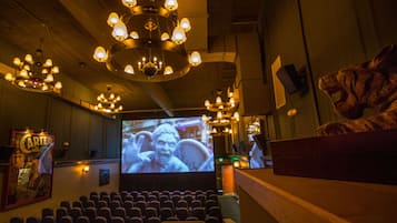 Un théâtre doté de plusieurs lustres, d’un grand écran et de rangées de sièges.