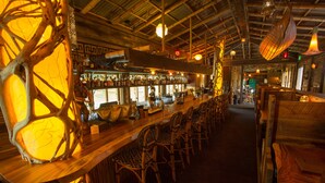 A bar area with wooden chairs and a long counter with bottles. - McMenamins Anderson School (Bothell)