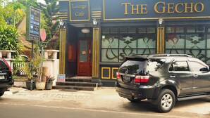 Un edificio con un letrero que dice "The Gecho Lounge Café" y "Executive Rooms".