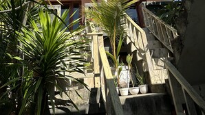 Um edifício com telhado curvo e escadaria que leva a uma varanda.