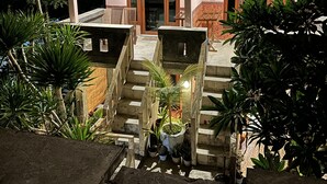 Um edifício com um telhado grande e escuro e uma escadaria que leva a uma porta com o número 6.