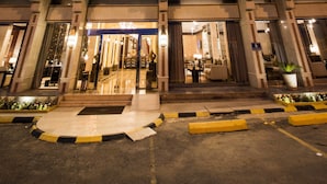 Ein Hotel mit markantem Eingang, mehreren Balkonen und einem Schild, das angibt, dass es sich um ein Boudh Hotel handelt.