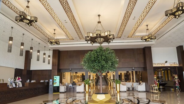 A hotel lobby with a reception desk, seating area, and a decorative tree centerpiece. - Western Hotel - Madinat Zayed (Madinat Zayed)
