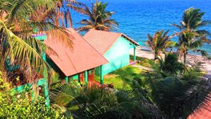 A beachside property with a small building, palm trees, and a view of the ocean. - Hiep Hoa Resort (Mui Ne)