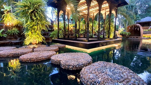 A tranquil indoor garden with a central gazebo, a reflective pool, and stone seating areas. - Villa Habeebee (Krabi)