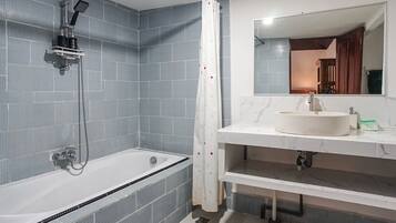 A modern bathroom with a bathtub, a shower, and a sink.