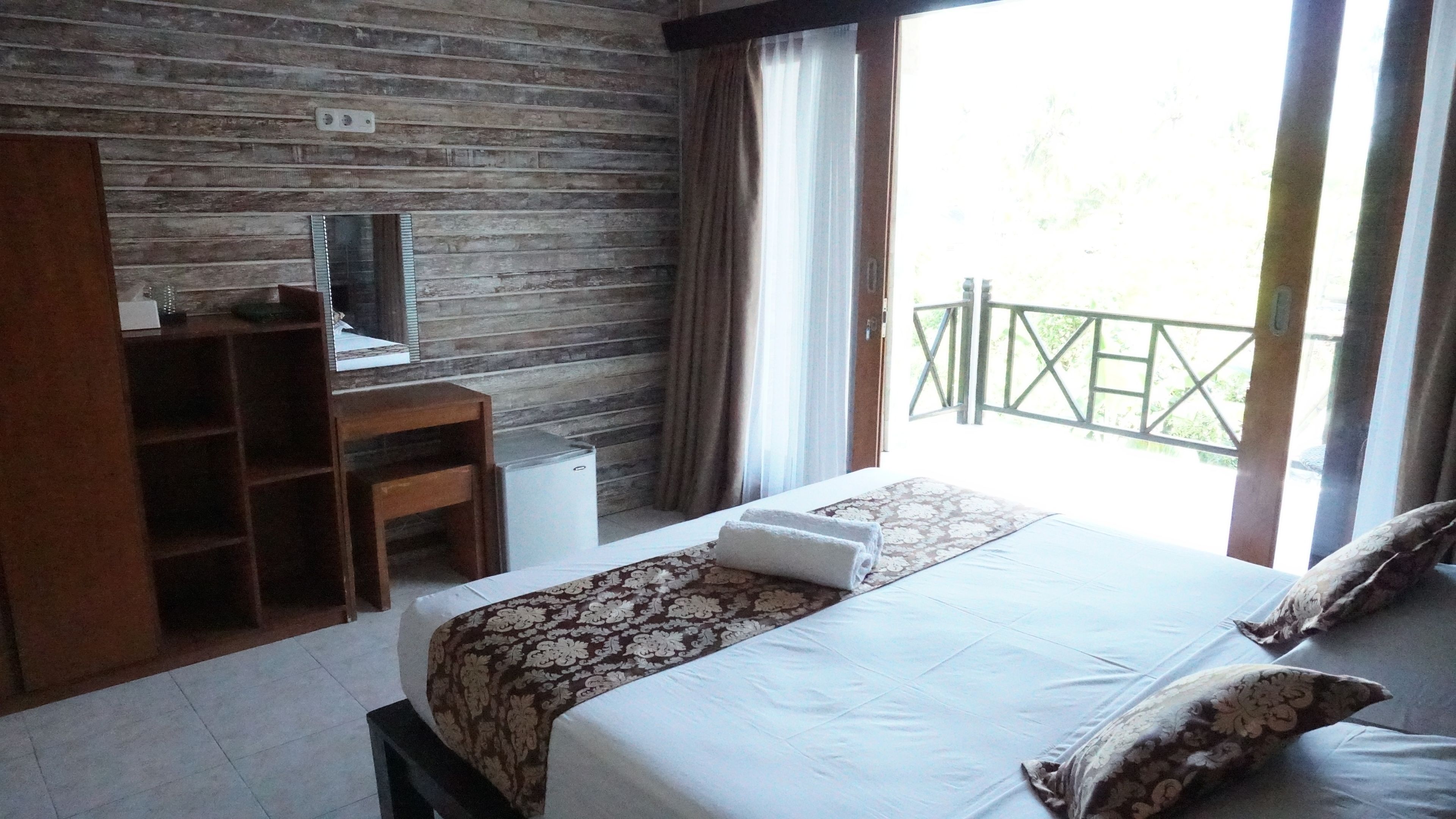 A bedroom with a bed, a desk, and a television.