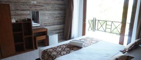 A bedroom with a bed, a desk, and a television.