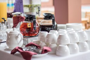 A breakfast setup with a teapot, a coffee pot, and multiple cups and plates. - River Top Lodge (Ngapali)