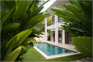 A modern two-story house with a swimming pool surrounded by lush greenery. - Moonlight Bali (Nusa Dua)