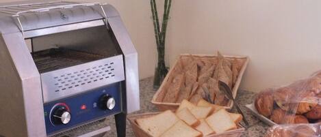 Eine Küche mit einem Toaster, einem Brotkorb und einer Auswahl an Gebäck.