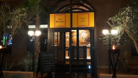 A restaurant entrance with a sign reading "The Winners" and "Sports & tapas".