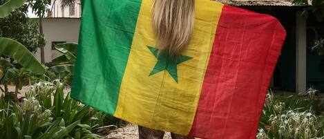 A person standing in a garden with a flag.