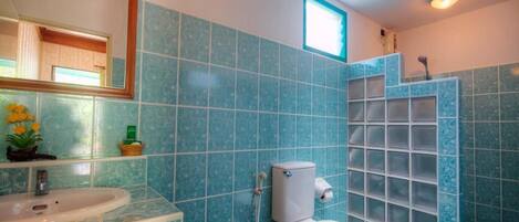 Un baño con inodoro, lavabo y cabina de ducha.