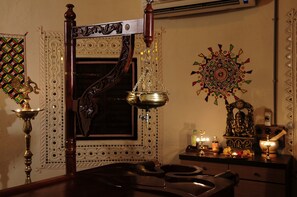 Ein traditionell eingerichteter Raum mit einem Spiegel, einer Messinglampe und Wandzierde.