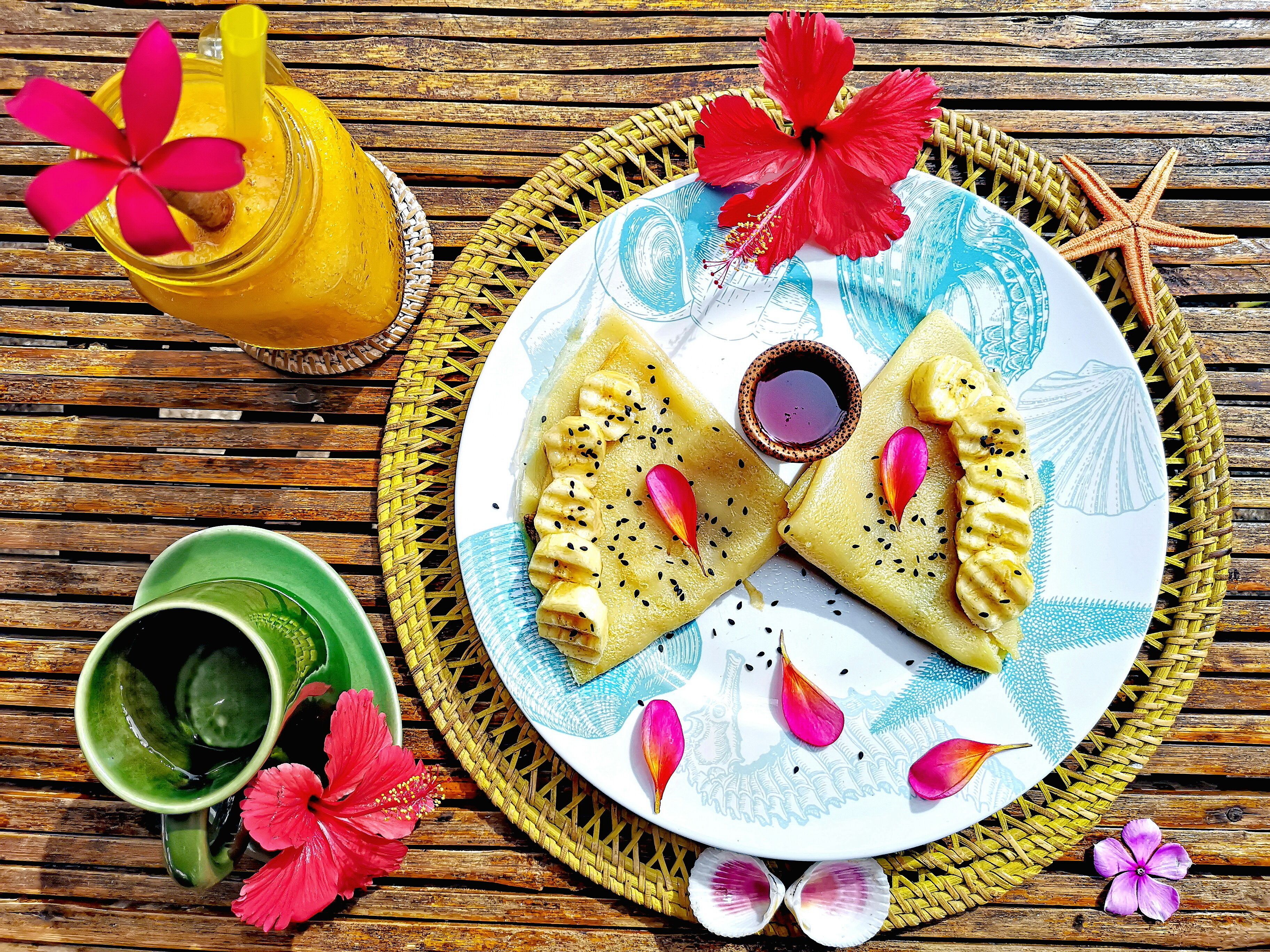 A plate with food, a drink, and decorative elements on a wooden surface.