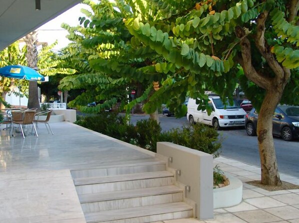 A covered outdoor seating area with a staircase leading to a higher level.
