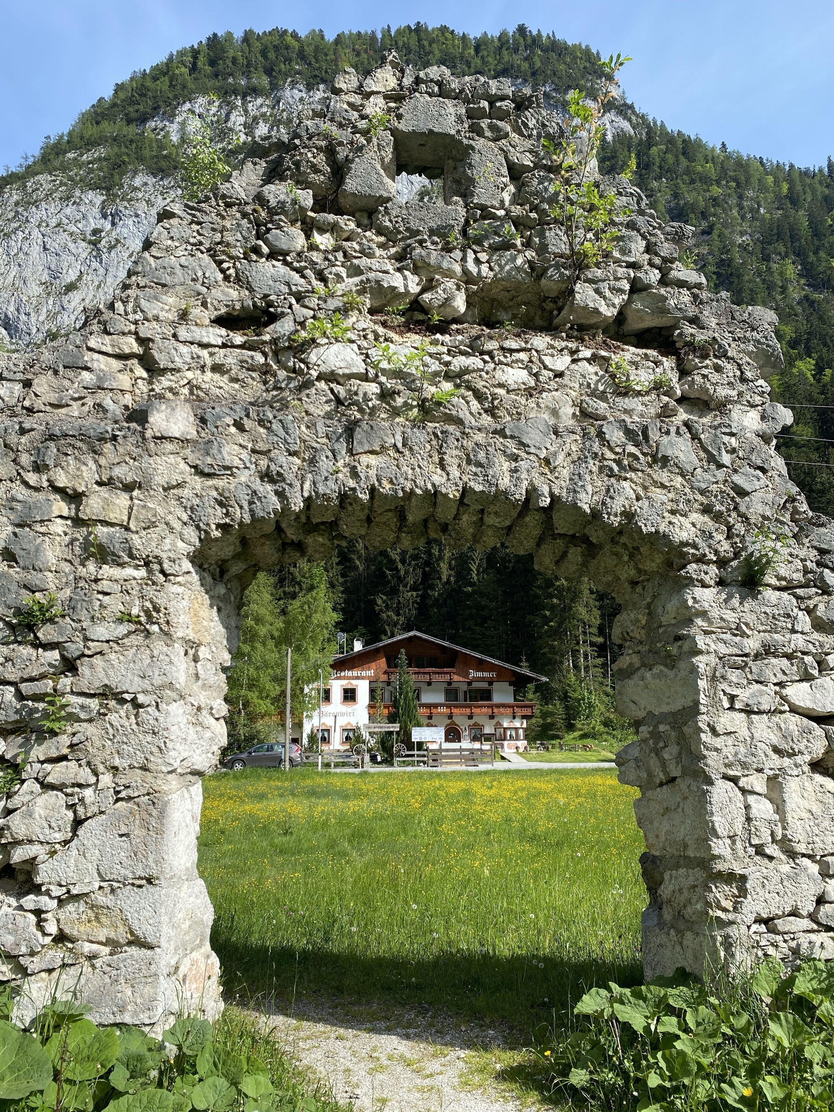 Un arco de piedra que da acceso a un edificio con un letrero que dice 'Restaurant'.