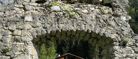 Un arco de piedra que da acceso a un edificio con un letrero que dice 'Restaurant'.