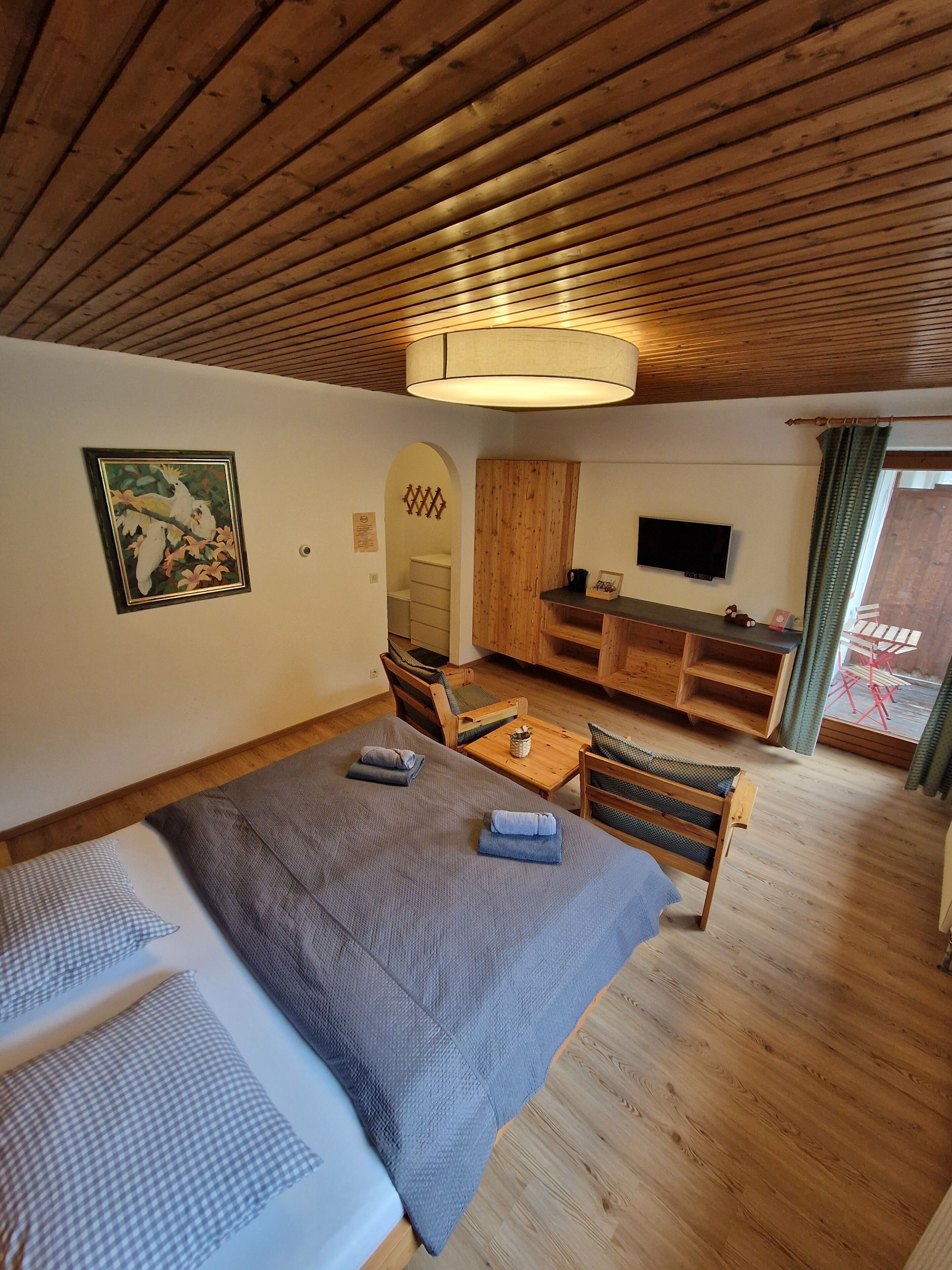 Une pièce confortable avec un lit, un bureau, une chaise et un téléviseur.