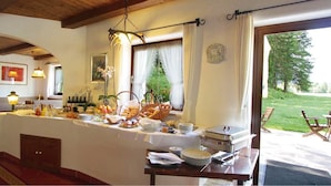 Een ontbijtbuffet met diverse gerechten en uitzicht op het omliggende landschap.