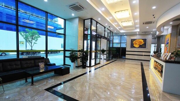 A spacious lobby with a black sofa, a reception desk, and large windows overlooking a parking area. - Inter City Seoul (Seoul)